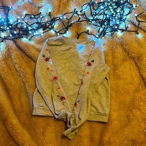 Very small orange paint stain on front. Floral on sleeves